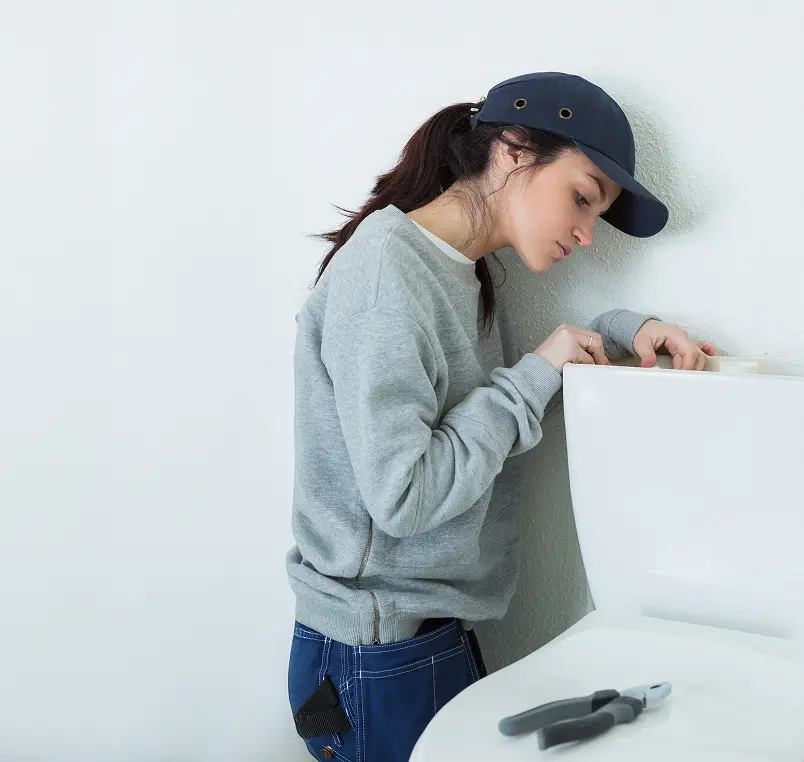 Woman checking her toilet's tank